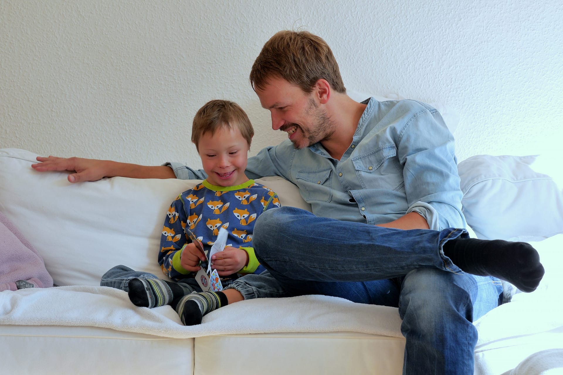 Portrait: Vater mit Sohn auf Sofa